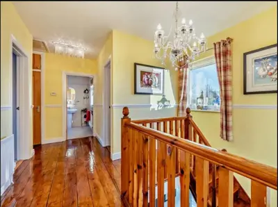 a room with a staircase and a chandelier at Blengfell by Prestige Properties SA in Gosforth