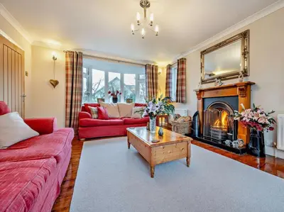 a living room with a red couch and a fireplace at Blengfell by Prestige Properties SA in Gosforth