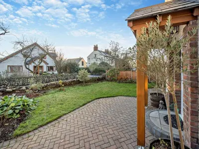 a backyard with a garden with a stone patio at Blengfell by Prestige Properties SA in Gosforth