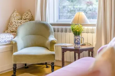 a living room with a chair and a table with a lamp at 3 Bed in Waberthwaite oc-n34154 in Waberthwaite