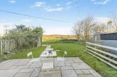 a patio with chairs and a table in a yard at 3 Bed in Waberthwaite oc-n34154 in Waberthwaite