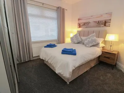 a bedroom with a bed with two blue towels on it at Marchdyke Farm Cottage in Lockerbie