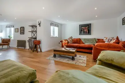 a living room with orange couches and a table at 3 Bed in Wigton oc-f33746 in Westward