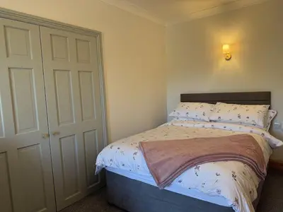 a small bedroom with a bed and a door at The Cottage in Keswick