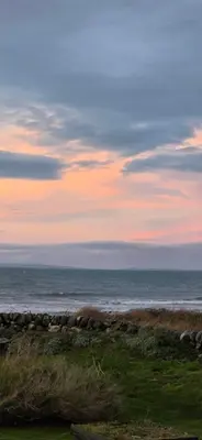 a view of the ocean from a beach at sunset at 17 Ruby Atlas Monreith in Monreith
