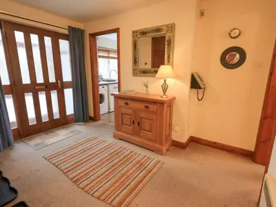 a living room with a table and a mirror and a door at Thrang View in Ambleside