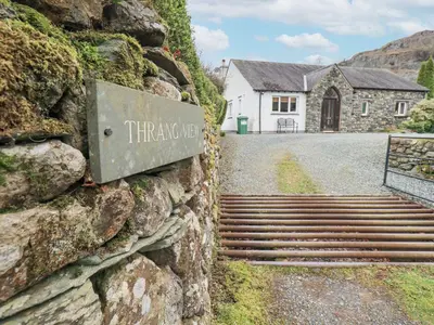 a sign on the side of a stone wall with a house at Thrang View in Ambleside