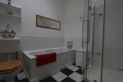 a bathroom with a tub and a shower and a toilet at Moir Cottage in Portpatrick