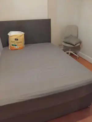 a bed in a room with a chair at A room in a house in Moffat