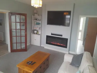 a living room with a fireplace and a tv at 2-Bedroom Flat South Ayrshire in Troon