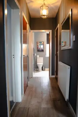 a hallway of a bathroom with a toilet and a sink at 2-Bedroom Flat South Ayrshire in Troon
