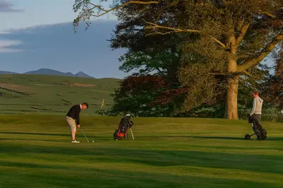 a group of people playing golf on a golf course at Feather Bed Cottage - Dog Friendly Lakeland Retreat with Log Burner & Garden