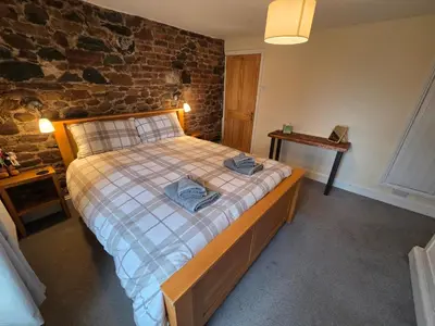 a bedroom with a bed with two towels on it at Feather Bed Cottage - Dog Friendly Lakeland Retreat with Log Burner & Garden