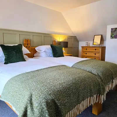 a bedroom with two beds with green pillows at The Wigtown Ploughman in Wigtown