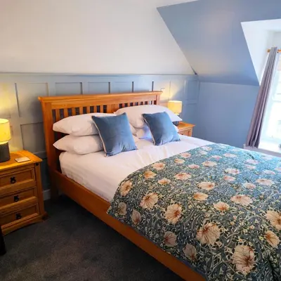 a bedroom with a large bed with a floral bedspread at The Wigtown Ploughman in Wigtown