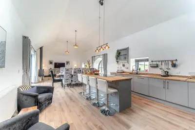 a kitchen and living room with a table and chairs at 5 Bed in Galston oc-s33451 in Galston