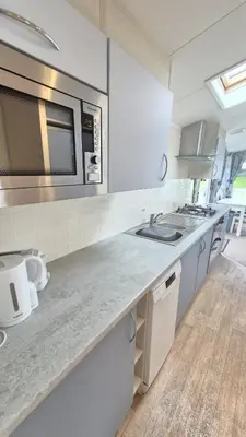 a kitchen with a sink and a microwave at Caravan Bliss in Minishant