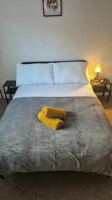 a bed with a yellow towel on top of it at Cockermouth Cottage - Lakes - Parking in Cockermouth
