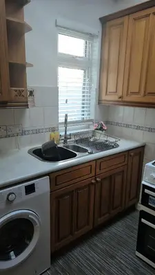 a kitchen with a sink and a washing machine at Cockermouth Cottage - Lakes - Parking in Cockermouth
