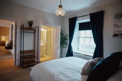 a bedroom with a bed and a window and a mirror at Bankhouse in Troon