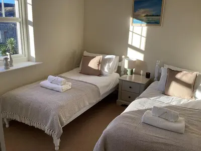 a bedroom with two beds with towels on them at Seascape - a Luxury Retreat on the Sea in Moffat