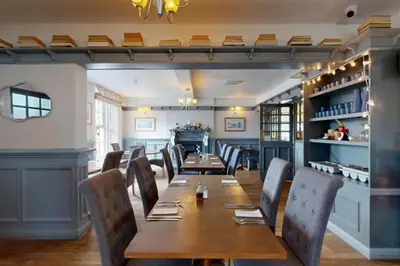 a dining room with a wooden table and chairs at The Briery in Workington