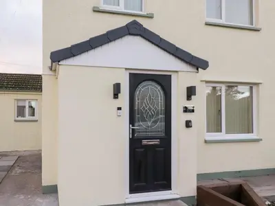 a black door on a white house at Mables in Wigton