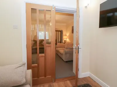a door leading into a living room with a couch at Mables in Wigton