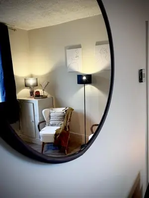 a mirror reflecting a room with a chair and a lamp at Central Carlisle Modern 4BD w Wi-Fi, Washer, & SmartTVs, close to M6 in Carlisle