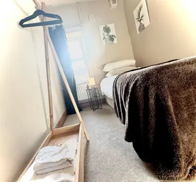 a room with a bed and a dresser with a mirror at Central Carlisle Modern 4BD w Wi-Fi, Washer, & SmartTVs, close to M6 in Carlisle