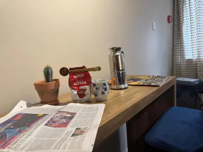 a table with a newspaper and a coffee maker on it at Central Carlisle Modern 4BD w Wi-Fi, Washer, & SmartTVs, close to M6 in Carlisle