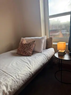a bed with two pillows on it in a room with a window at Central Carlisle Modern 4BD w Wi-Fi, Washer, & SmartTVs, close to M6 in Carlisle