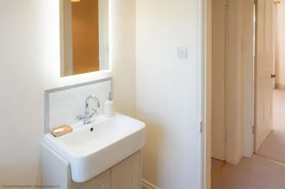 a bathroom with a white sink and a mirror at Craignair in Castle Douglas