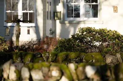 a stone wall in front of a house at Craignair in Castle Douglas