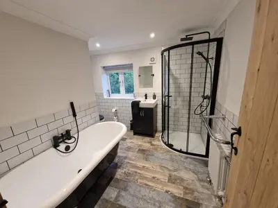 a bathroom with a bath tub and a shower at The Old school House in Moffat