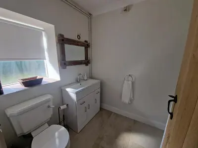 a bathroom with a white toilet and a window at The Old school House in Moffat