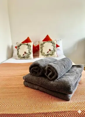 a bed with towels sitting on top of it at Entire 1 bedroom in VAUXHALL Central London Zone 1 in Moffat