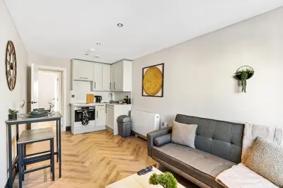 a living room with a couch and a kitchen at Newly Renovated 1BR Steps from Hove Beach in Moffat