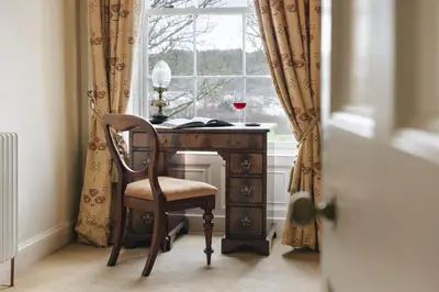 a desk with a glass of wine sitting next to a window at Seaside ParkView Near Lake District and Marina - Pass the Keys in Whitehaven