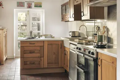 a kitchen with wooden cabinets and a stove top oven at Seaside ParkView Near Lake District and Marina - Pass the Keys in Whitehaven