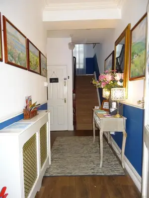 a living room with a table and a hallway at Bed And Blueberry Two Bed Suite for 2,3, or 4 people in Douglas