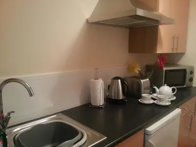 a kitchen counter with a sink and a microwave at Bed And Blueberry Two Bed Suite for 2,3, or 4 people in Douglas