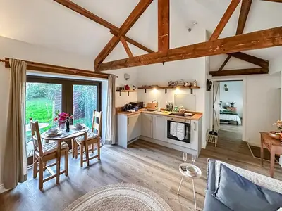 a kitchen and living room with a table and a kitchen and a dining room at Lime Tree Barn in Tallentire