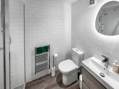 a white bathroom with a toilet and a sink at Lime Tree Barn in Tallentire
