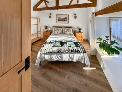 a bedroom with a bed and a wooden floor at Lime Tree Barn in Tallentire