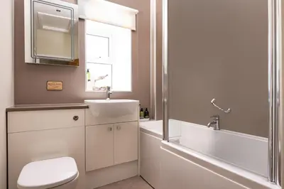 a bathroom with a toilet and a sink and a tub at Orroland Holiday Cottages in Dundrennan