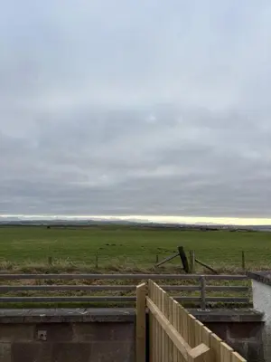 a view of a field with a fence and a field with at Cross Beck Cottage in Allonby