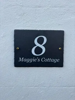 a sign on a wall with the name of a mageacers conference at Maggies Cottage in Little Broughton