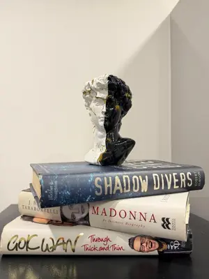 a stack of books with a statue on top of them at Cosy Greenwich Flat Near -Cutty Sark, River & Park in Moffat