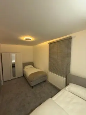 a bedroom with two beds and a window in it at Cosy Greenwich Flat Near -Cutty Sark, River & Park in Moffat